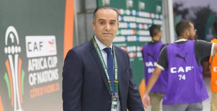 Walid Sadi à l'honneur : le boss de la FAF s'apprête à vivre une consécration inédite Walid Sadi en costume lors d'un événement football en Algérie.