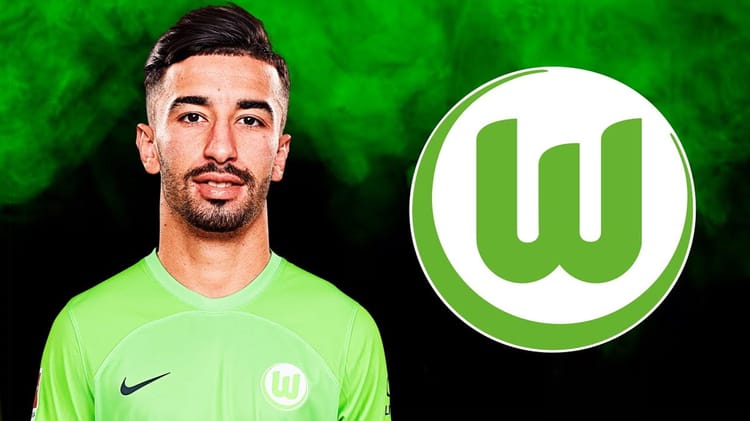 Karim Ziani porte un maillot vert avec le logo de Wolfsburg en arrière-plan.