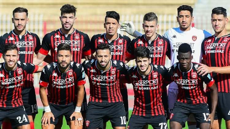 Groupe de joueurs de football de l'USM Alger en action sur le terrain.