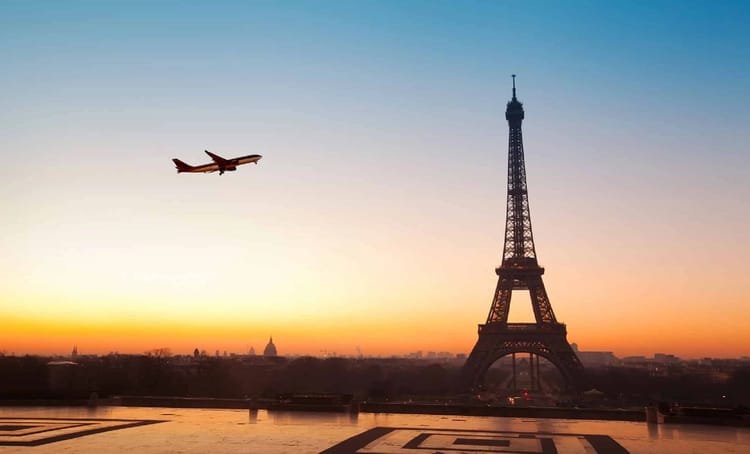 JO Paris 2024 : Fermeture de l'espace aérien pour la cérémonie d'ouverture Avion volant près de la Tour Eiffel au crépuscule à Paris.