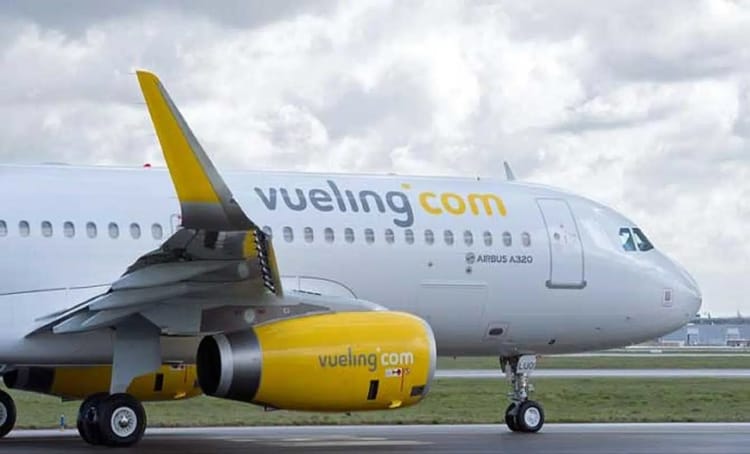 Billets annulés durant le Covid-19 : Vueling déterminé, à rembourser ses dettes Avion Vueling avec logo jaune et blanc sur piste d'aéroport.