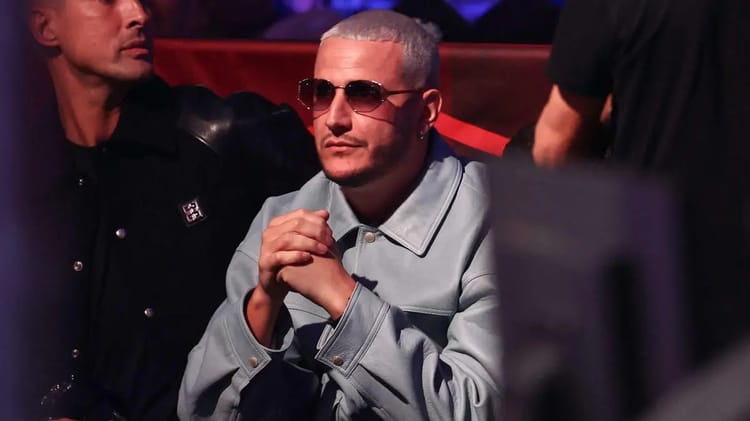 DJ Snake portant des lunettes de soleil et une veste grise lors d'une apparition publique.