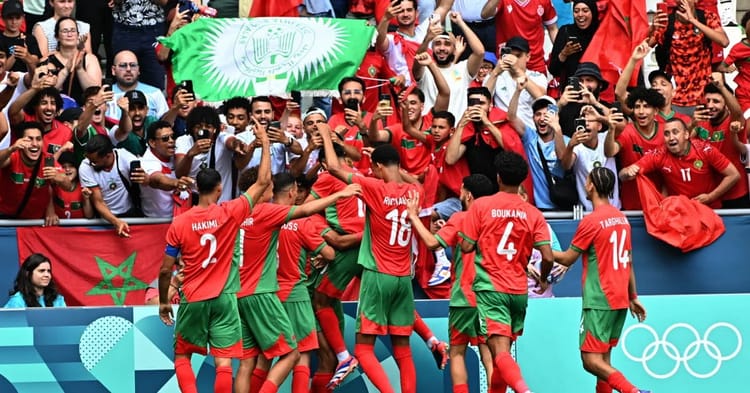 Les joueurs marocains célèbrent leur victoire devant des supporters enthousiastes.