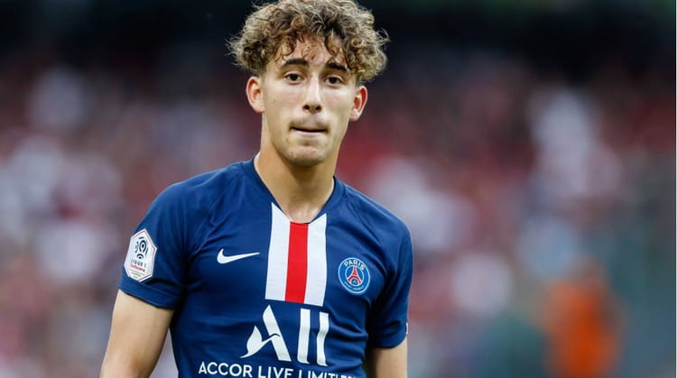 Adil Aouchiche, joueur de football en maillot PSG, sur le terrain.