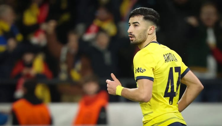 Mohamed Amoura portant le maillot jaune, en pleine action sur le terrain.
