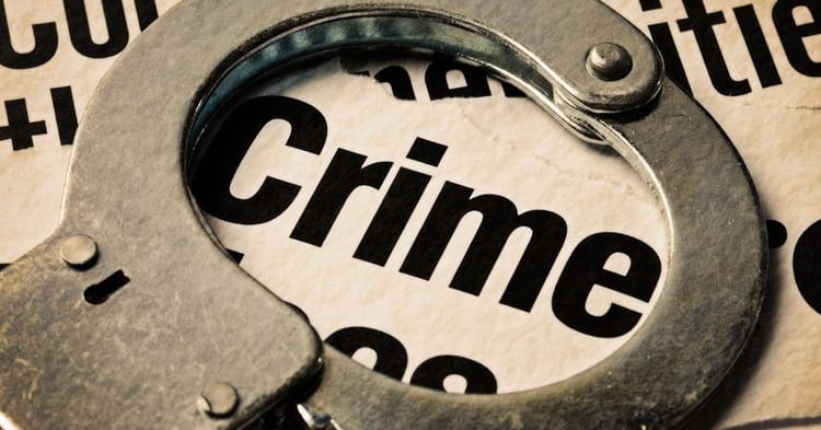 Menottes en métal avec le mot 'Crime' en arrière-plan.