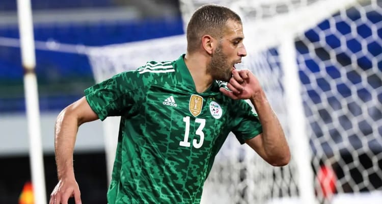 Islam Slimani, joueur algérien, célèbre après un but lors d'un match de football.