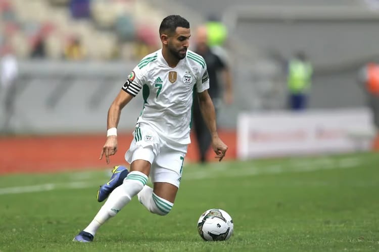 Riyad Mahrez en maillot des Verts, prêt à tirer le ballon.