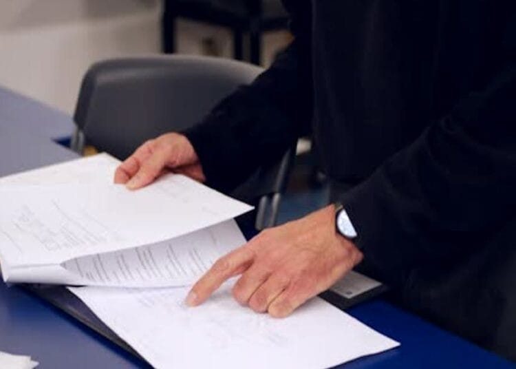 Personne vérifiant des documents administratifs pour le concours.