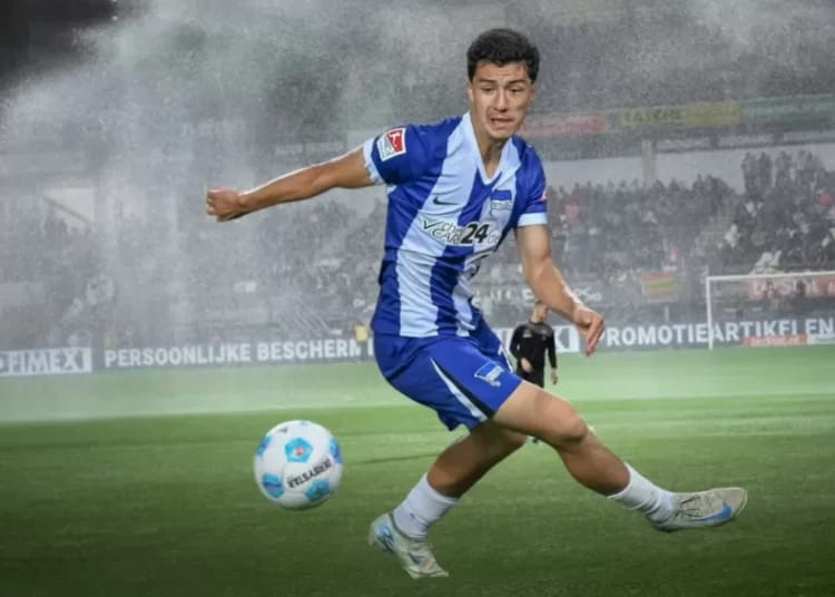 Jeune joueur de football en pleine action sur le terrain.