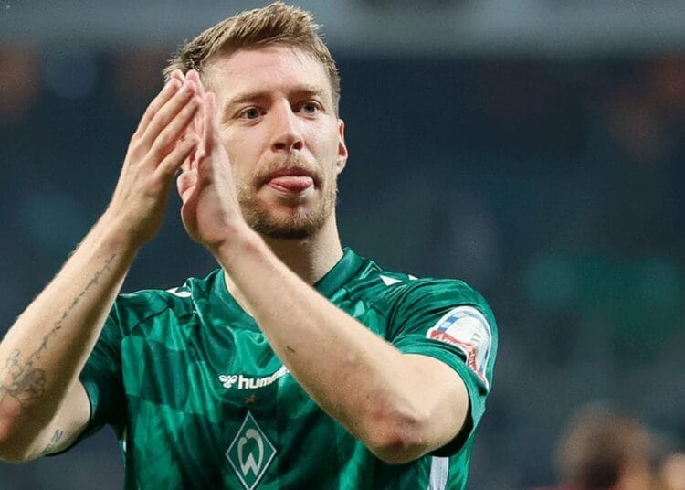 Mitchell Weiser en tenue de football, saluant le public.