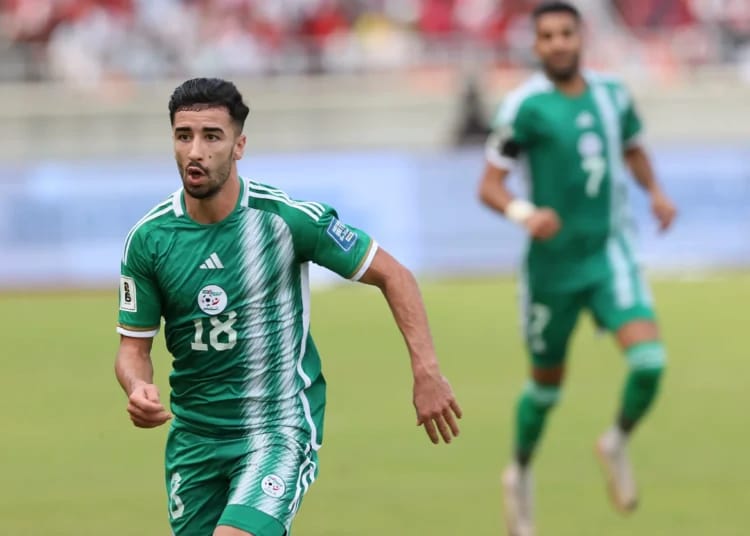 Footballeur en maillot vert en pleine course sur le terrain.