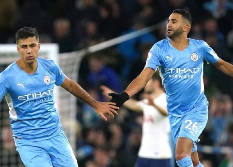 Riyad Mahrez en action avec un coéquipier lors d'un match de football.