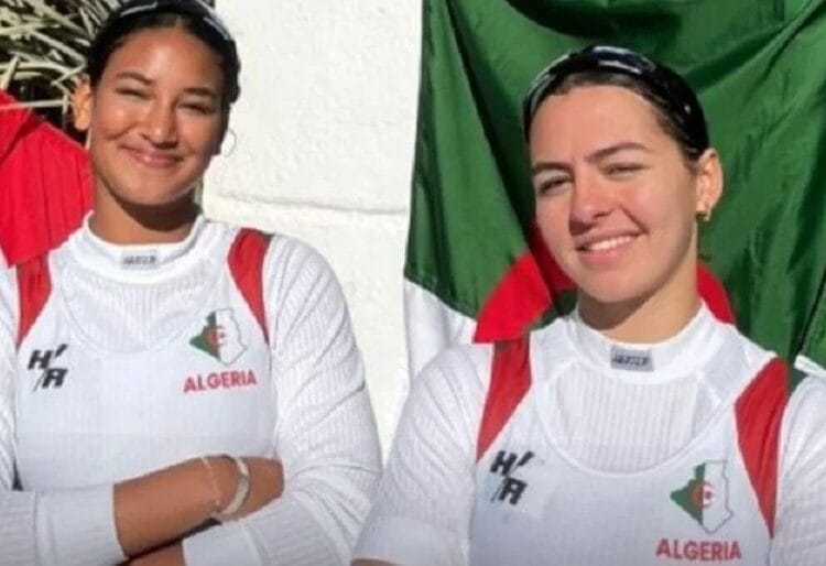 Championnats arabes 2024 : L’Algérie décroche sa première médaille d’or Deux athlètes algériennes souriantes avec drapeau algérien en arrière-plan.