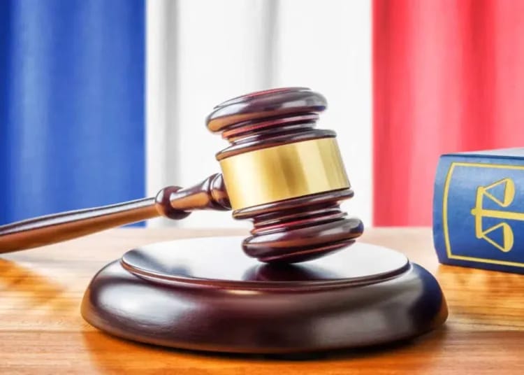 Marteau de juge et livre de droit sur une table en bois.