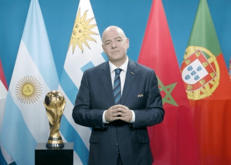 Coupe du monde 2030 : La FIFA prend à contre pied le Maroc, une gifle diplomatique pour Rabat Homme en costume devant drapeaux de différents pays et trophée mondial.