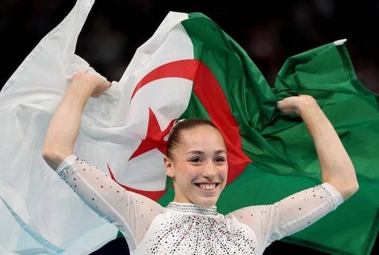 Jeune femme avec drapeau algérien lors d'une célébration nationale.