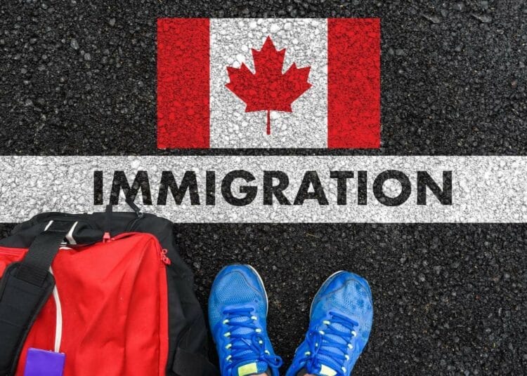 Chaussures et sac à dos sur une route avec drapeau canadien et mot 'Immigration'.