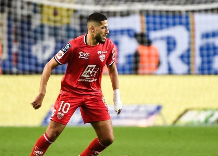 Yassine Benzia portant le maillot rouge en pleine action sur le terrain.