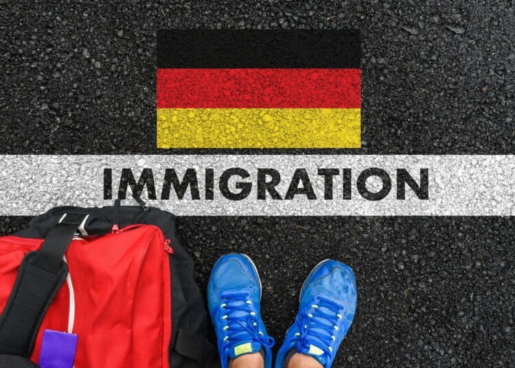 Marquage au sol pour l'immigration en Allemagne avec valise et chaussures.
