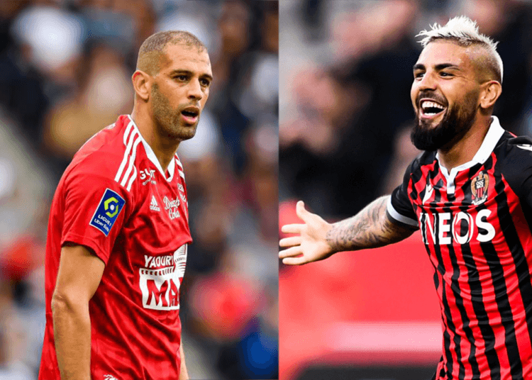 MC Alger-CR Belouizdad : Un duel Slimani-Delort sous l’ombre de l’affaire Belaili Deux joueurs de football en action lors d'un match, portant des maillots rouges et noirs.