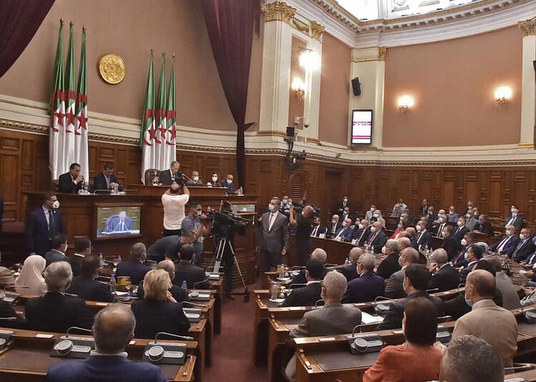 Débat politique en Algérie avec des représentants et un public nombreux.
