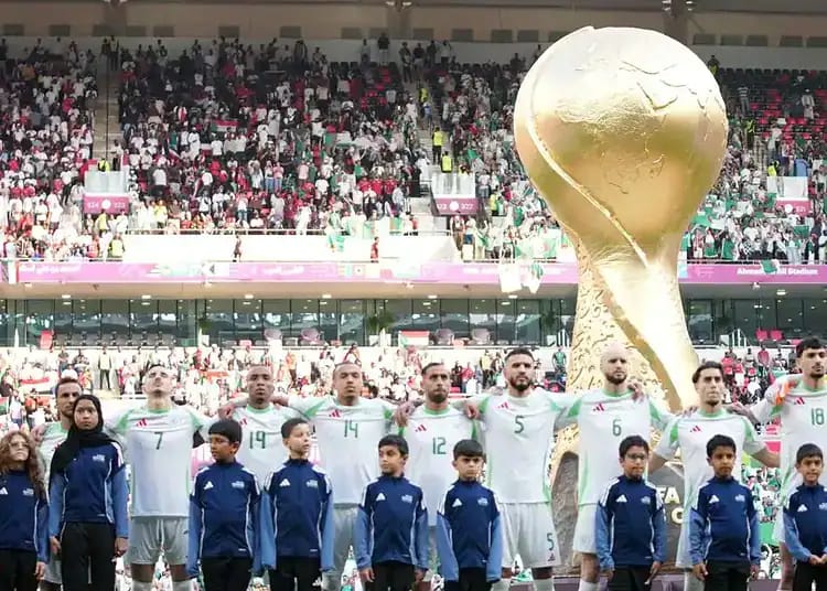 L'équipe algérienne de football avec la Coupe du Monde en tribune.