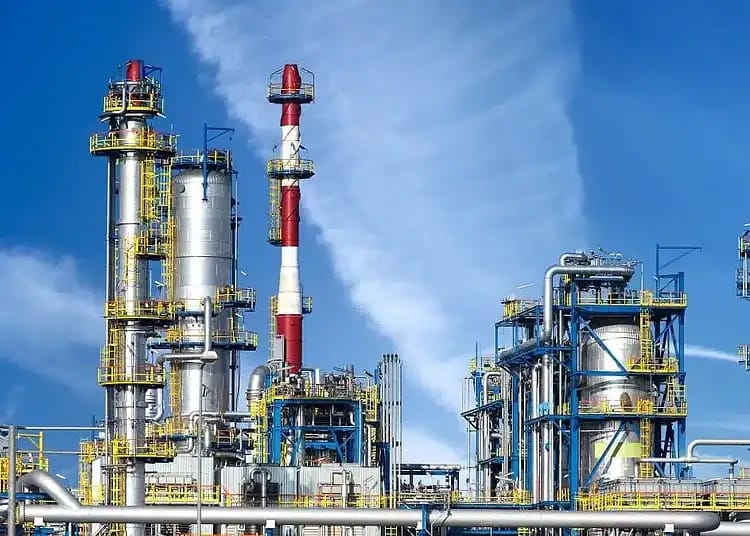 Le pétrole sous 60 $: quelles conséquences pour l’Algérie ? Installation pétrolière avec tours et pipelines sous ciel bleu.