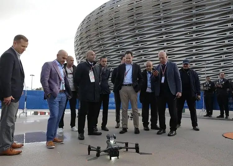 Groupe de personnes observant un drone en extérieur à Marseille.