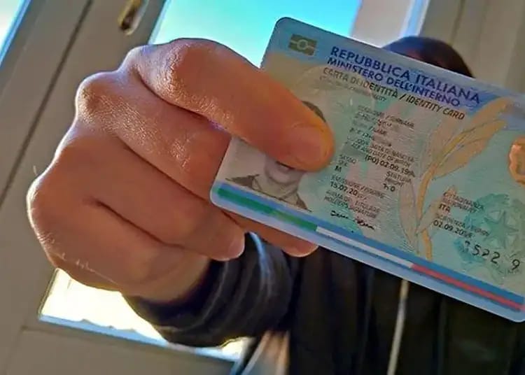 Italie : un nouveau permis unique pour les étrangers ? Personne tenant un permis de conduire italien avec fond clair.