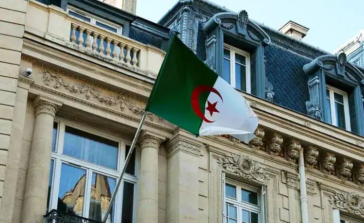 Découvrez l'info essentielle sur la permanence à Metz ! Drapeau algérien en haut d'un bâtiment historique à Alger.