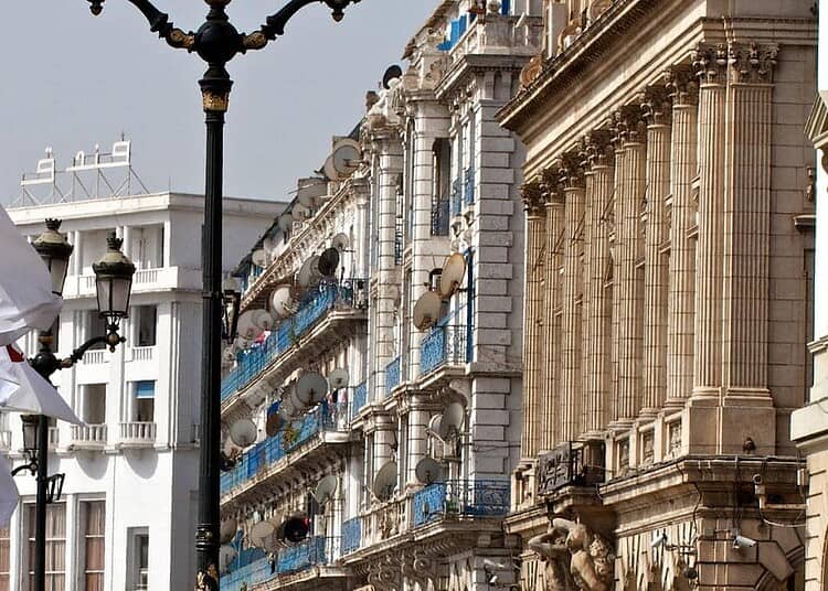 La République s'implique sur 1Tik : un tournant surprenant ! Drapeaux algériens flottant lors d'une manifestation dans une ville historique.