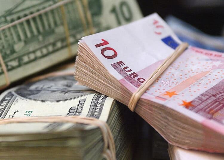 Foule de billets de banque en euros et dollars en gros plan.
