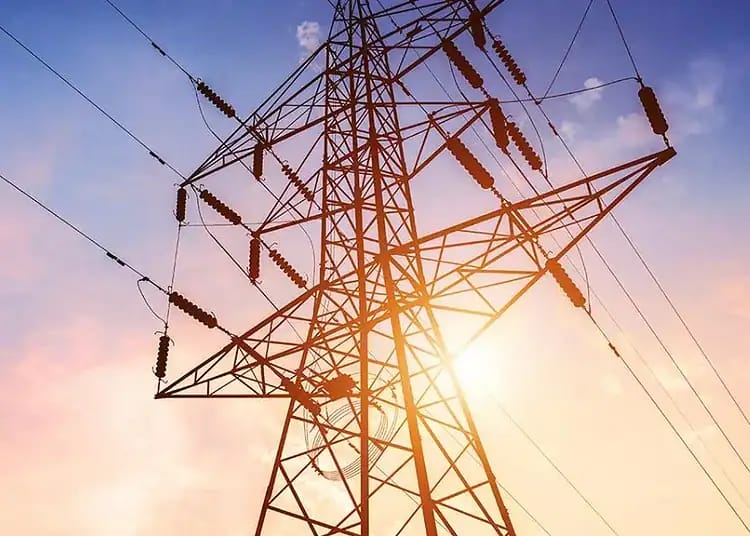 Pylône électrique en Algérie avec le soleil en arrière-plan.