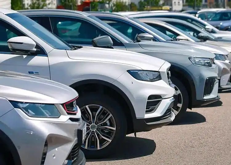 Voitures neuves alignées dans un parking en Algérie.