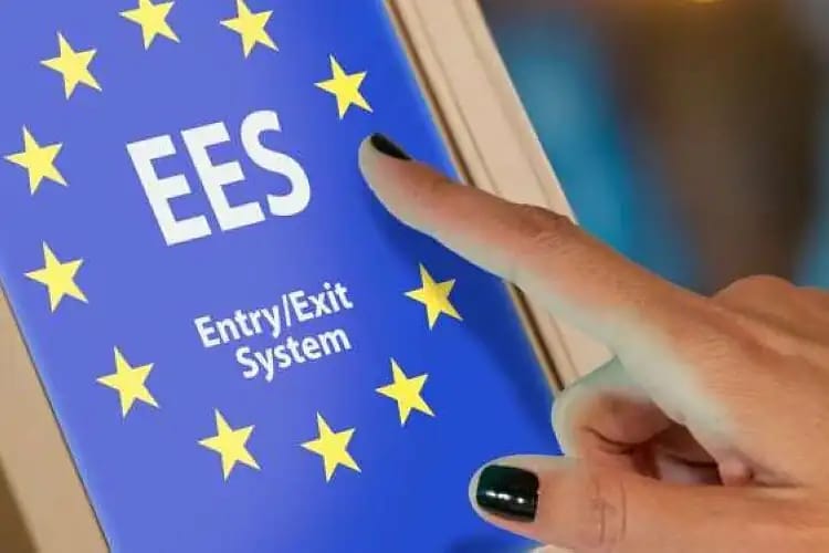Europe 2026 : nouveaux contrôles aux frontières en Schengen Main qui touche un smartphone affichant le système EES de Schengen.