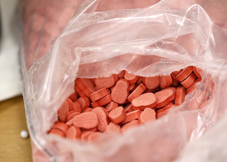 Comprimés d'ecstasy rouges dans un sac en plastique transparent.
