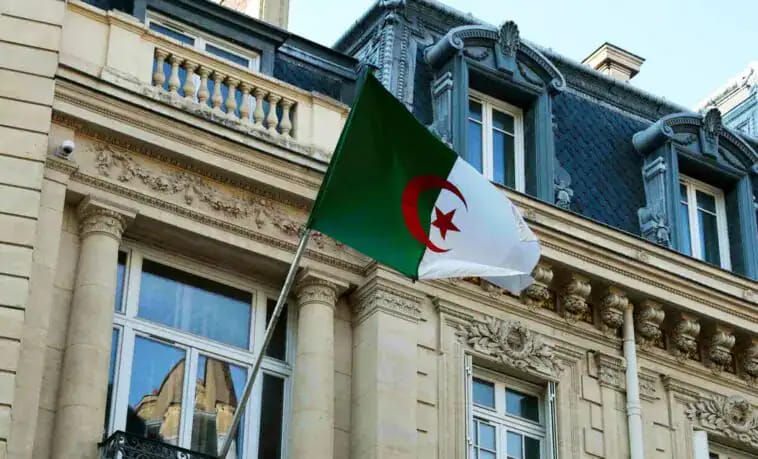 Drapeau algérien en haut d'un bâtiment historique à Alger.