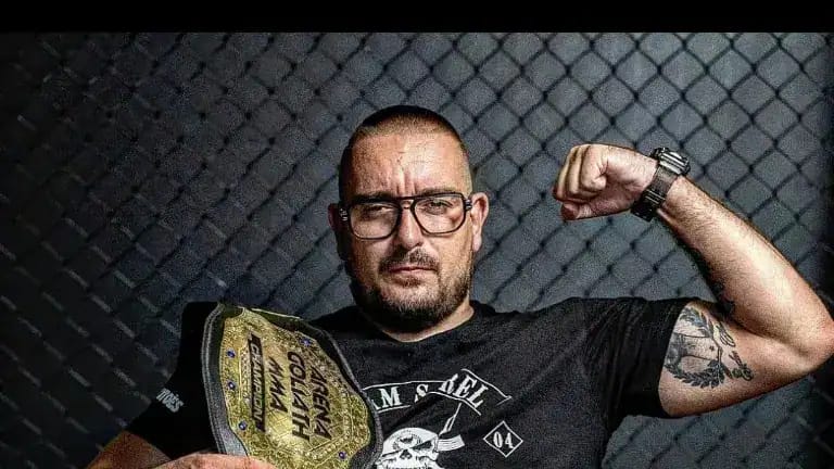 Yvan Sorel montrant son bras musclé dans une salle d'entraînement.