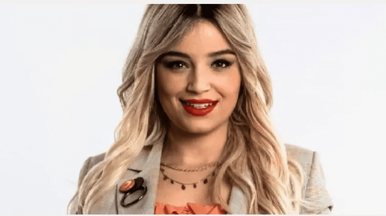 Numidia Lezoul : Bouyahiaoui parle Femme souriante avec cheveux blonds et maquillage rouge.