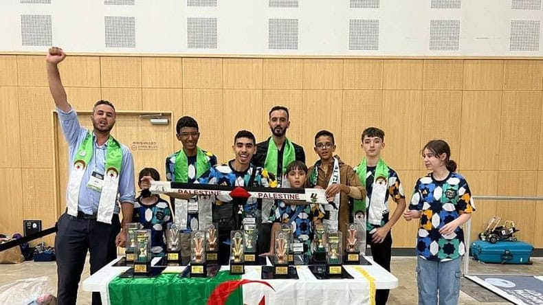 Groupe de jeunes avec trophées lors d'une compétition de robotique.