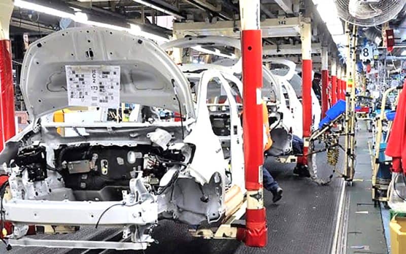 Ligne d'assemblage automobile en Algérie avec des voitures en construction.