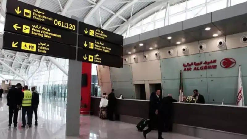Accueil à l'aéroport d'Alger avec panneaux d'information.