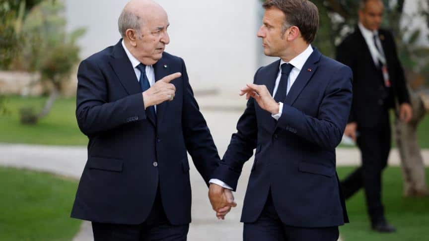 Deux hommes en costume discutent lors d'une rencontre officielle.