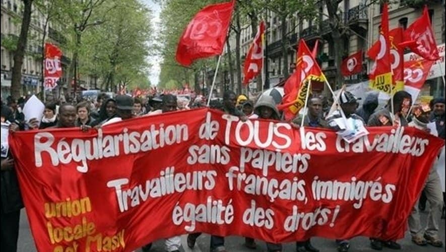 Manifestation avec drapeaux rouges pour l'égalité des travailleurs.