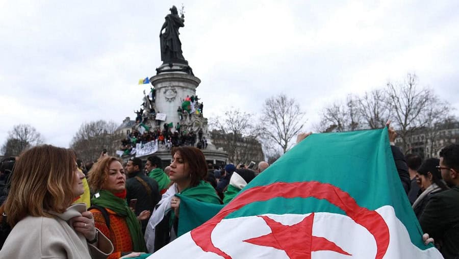 Manifestation en France pour soutenir l'Algérie avec drapeau algérien.