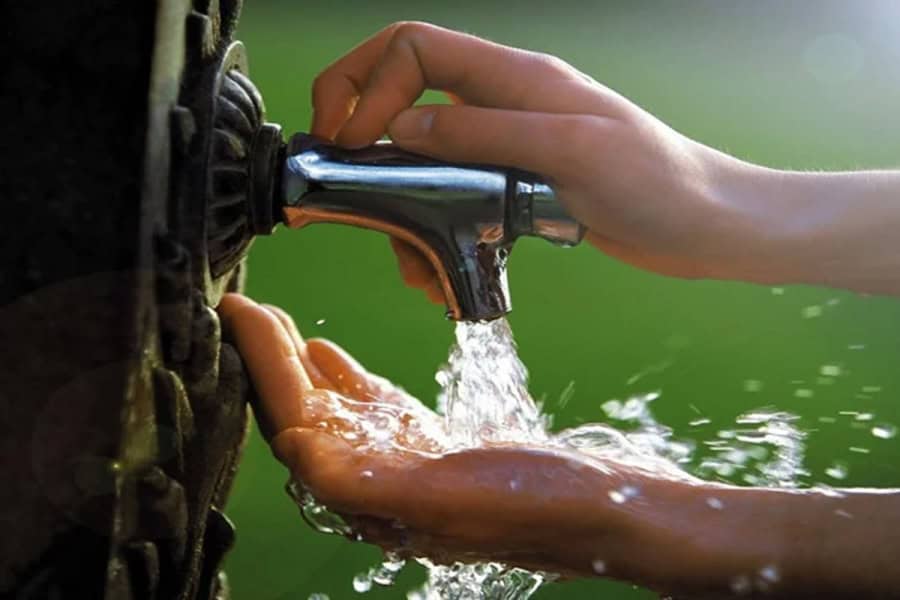 Main utilisant un robinet pour contrôler l’eau en cas de surprise d’eau.
