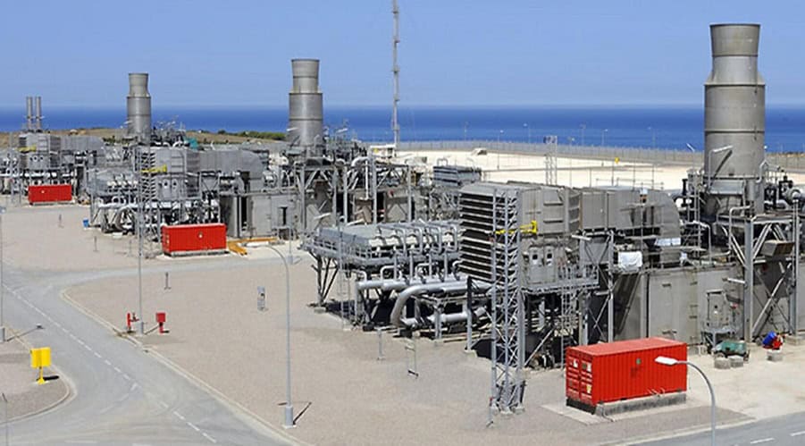 Usine de traitement de gaz naturel en Algérie avec vue sur la mer.