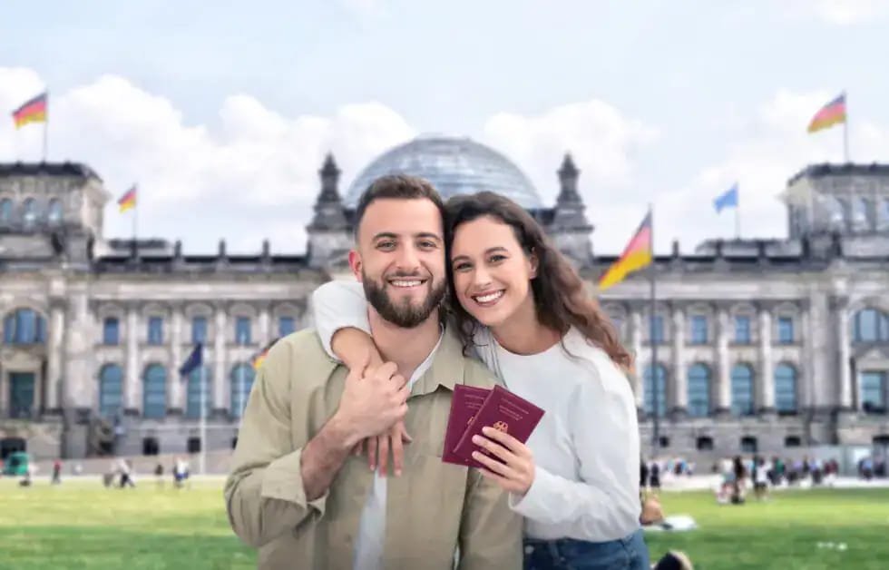Couple souriant avec passeports devant le Reichstag à Berlin.